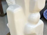 a white statue sitting on a table next to a plate of food