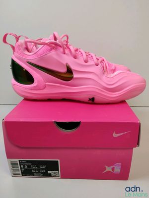 une boîte rose sur laquelle est posée une paire de chaussures