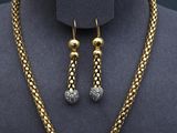 a close up of a necklace and earrings on a mannequin