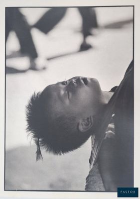 black and white photograph of a young boy looking up at a skateboarder
