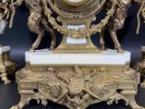 a gold clock that is sitting on top of a table