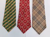 three different colored neck ties are lined up on a white surface