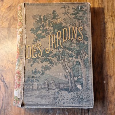 un vieux livre posé sur une table en bois près d'un arbre