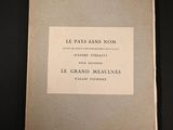 un vieux livre posé sur une table à côté d'une table noire