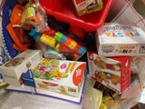 a pile of toys in a red bucket on the floor