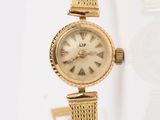 une image d'une montre-bracelet de femme sur une surface blanche