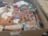 a cardboard box full of clothes that is sitting on the floor