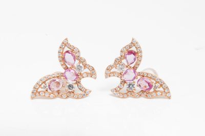 une paire de boucles d'oreilles en saphir rose et diamants sur fond blanc