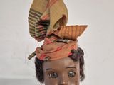 a small doll with a hat on top of it ' s head