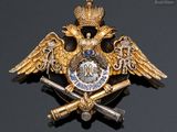 an image of a gold and silver broochle with a crown and two swords