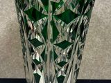 un vase en verre vert posé sur une table