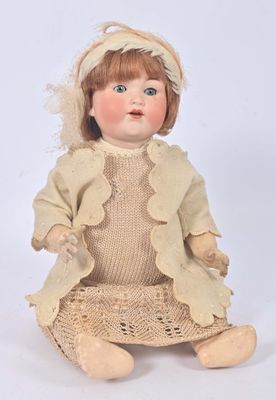 an image of a doll sitting on the ground wearing a dress and hat