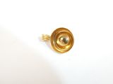 a gold ring with a button on it on a white surface