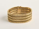 une image d'un bracelet en or sur fond blanc