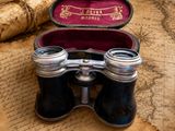 a pair of binoculars sitting on top of an old map
