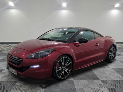 une photo d'une voiture de sport rouge sur un sol à damier