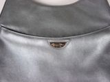 a close up of a silver purse with a metal handle