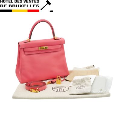 pink leather handbag with gold hardware on a white surface