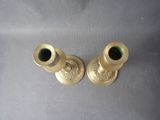 two brass candlesticks sitting on a table