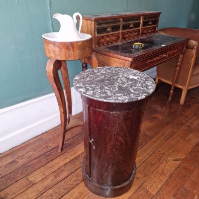 une petite table au plateau en marbre, à côté d'une autre petite table sur laquelle se trouve un vase