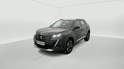 Une voiture grise est garée dans une pièce blanche.