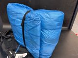 a blue bag sitting on a black table next to a black bag