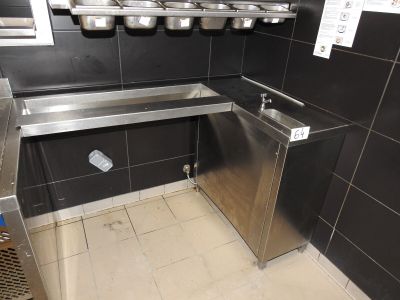 un évier en acier inoxydable dans le coin d'une toilette publique