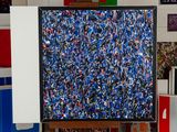 a painting on a easel in a room with many different colored boxes