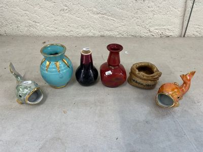 cinq vases différents posés par terre les uns à côté des autres