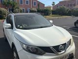 the white nissan qx is parked on the side of the road