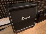 a black amp sitting on a wooden floor in front of a wall