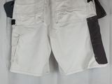a pair of white cargo shorts hanging on a white curtain