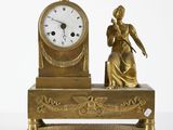 une horloge en or surmontée d'une statue