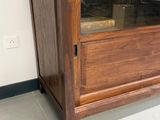une armoire en bois avec une porte vitrée sur le dessus