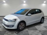 la volkswagen polo blanche est garée dans une pièce au sol en damier