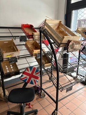 un chariot métallique sur lequel sont posées des caisses, avec une chaise devant