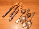 several spoons, forks and spoons sitting on a wooden table