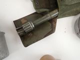 a green bag that has a shovel and some other items on it