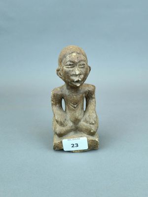 un gros plan sur une petite statue représentant une personne assise sur une table