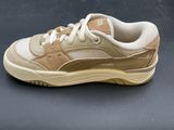 beige and white sneakers on a gray surface with a black background