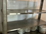 a metal shelf with plates on it in a kitchen