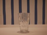 a glass that is sitting on a table in front of a striped wall