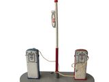 une petite maquette représentant une pompe à essence et un poteau