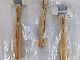 trois marteaux à manche en bois sont emballés dans des sacs en plastique sur une table