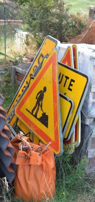 a pile of road signs that are sitting in the grass