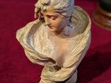 une statue de femme assise sur une table
