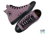 a pair of purple sneakers with black laces on them