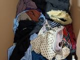 a cardboard box filled with clothes and a teddy bear