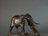 statue of an elephant on a rock with a gray background