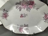 a white plate with pink flowers on it on a table